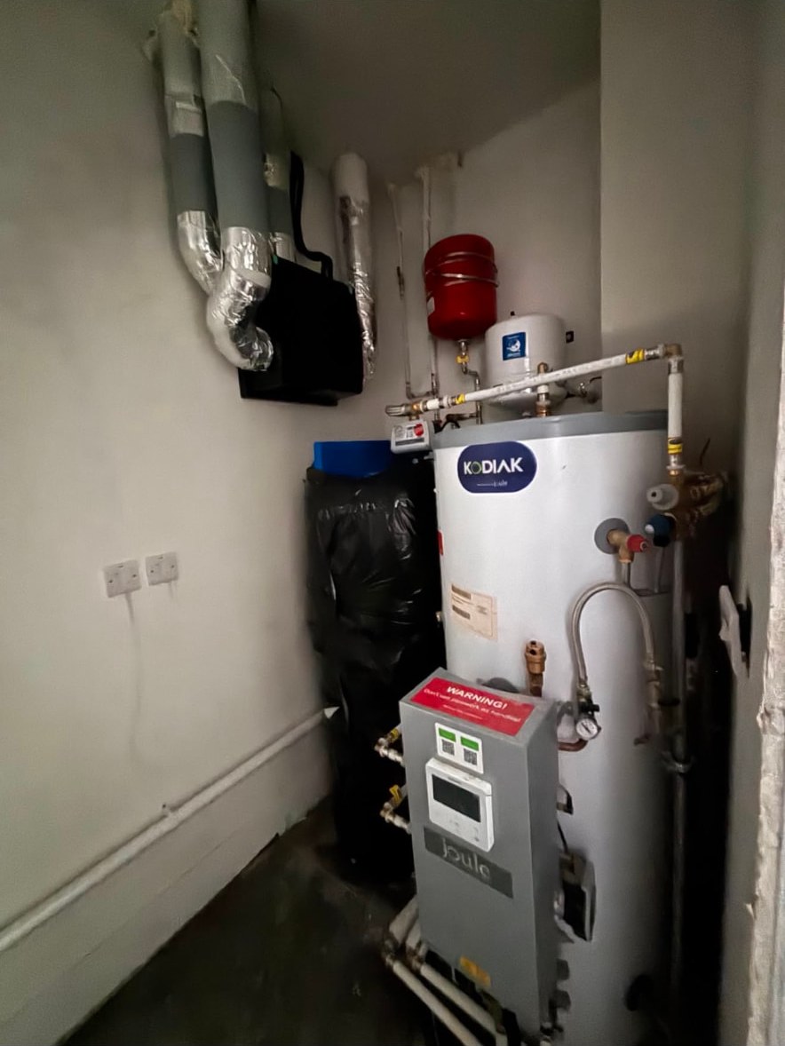 Plant space with a hot water cylinder, control panel, expansion vessels and insulated heat recovery ductwork