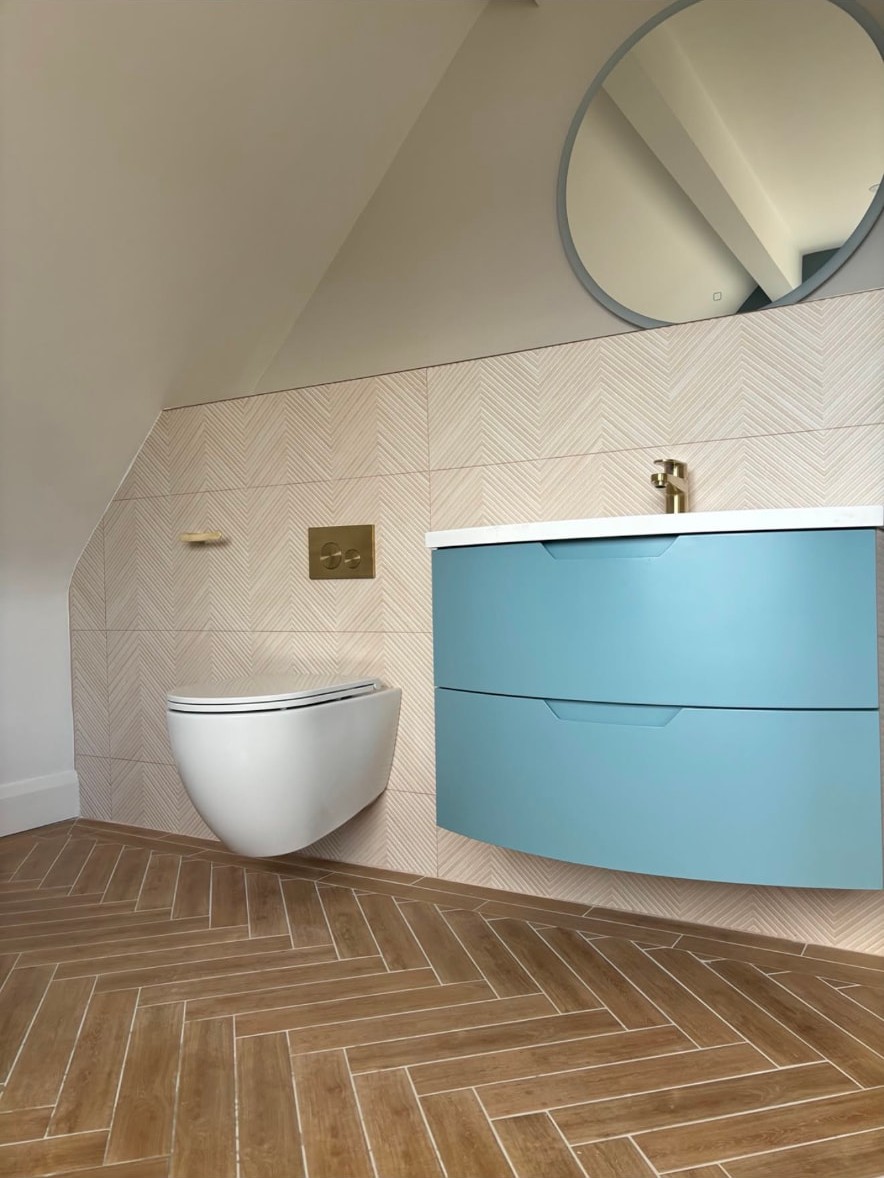Completed bathroom installation with panelled bath and electric shower