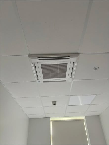 Four way ceiling cassette air conditioning unit installed in a suspended ceiling