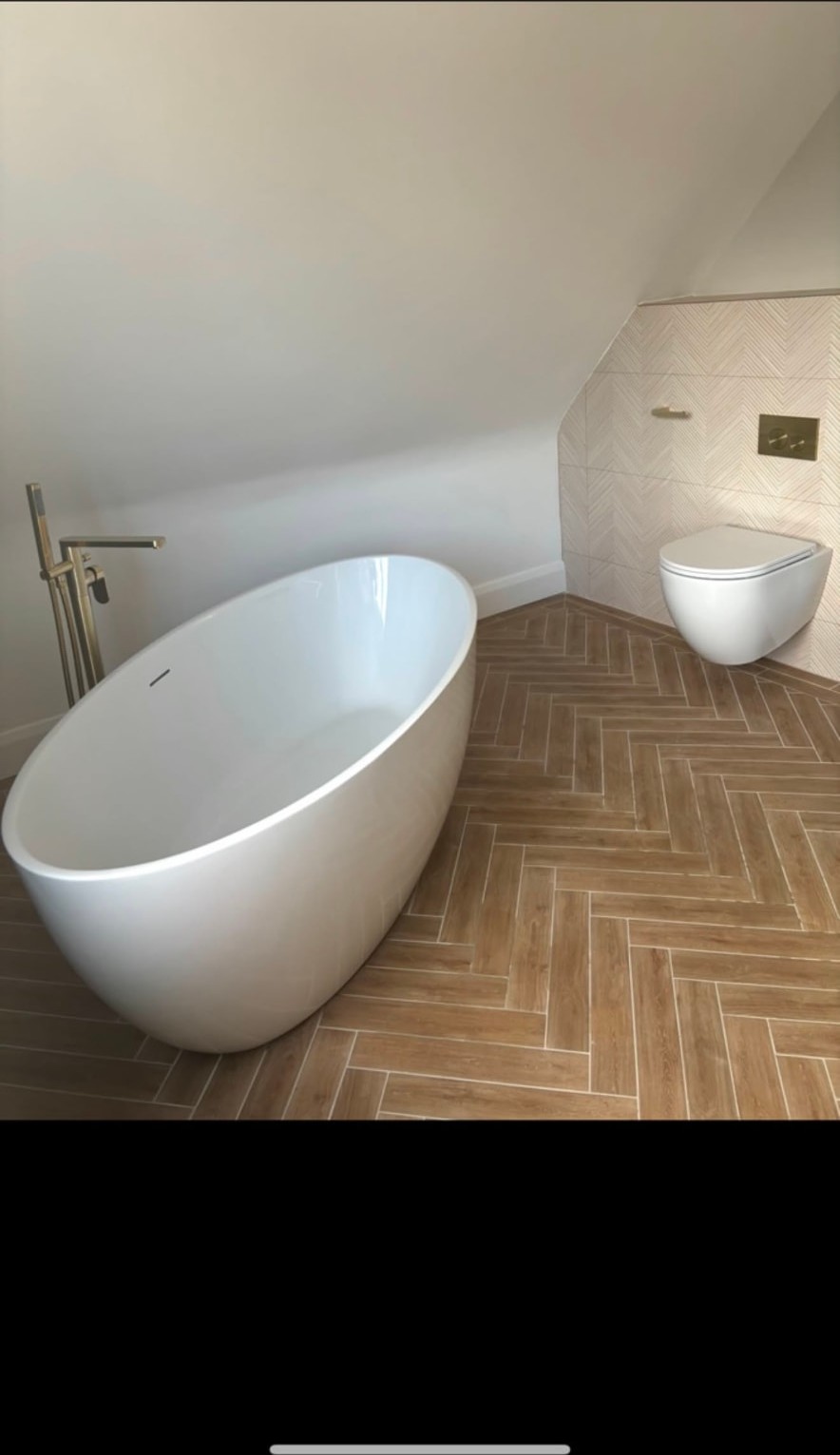 Completed bathroom with a freestanding bath, brushed brass floor standing tap and wall hung WC