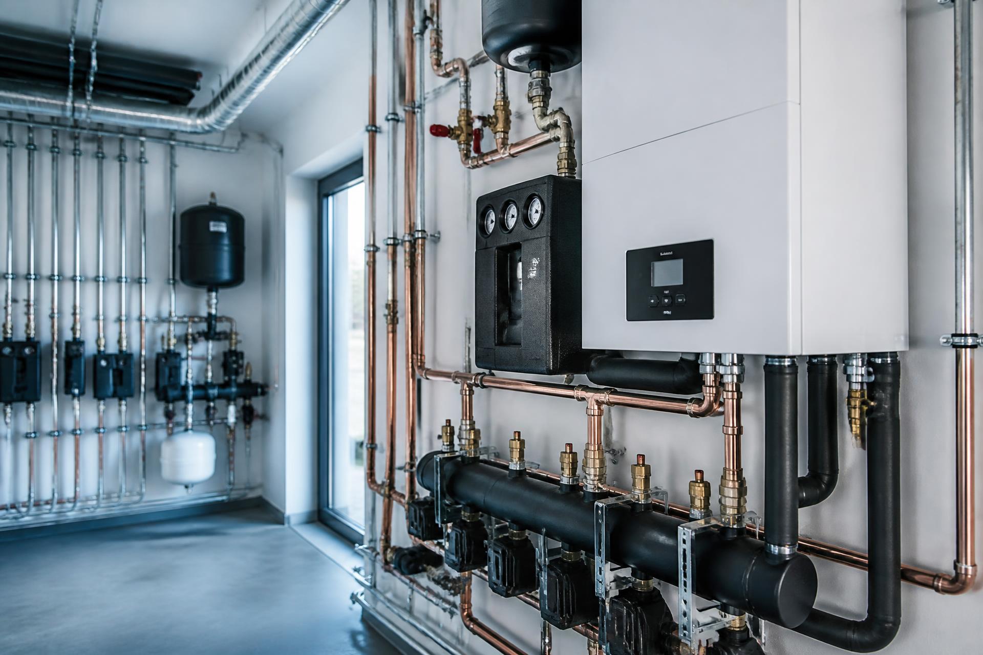 Modern heating plant room with neatly installed copper pipework and manifolds